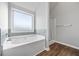 Bathroom with a soaking tub, tiled surround, separate shower, and wood-look flooring at 2098 Bridgewater Pass, Hampton, GA 30228