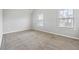 Bright bedroom with neutral walls, plush carpeting, and natural light from two windows at 2098 Bridgewater Pass, Hampton, GA 30228