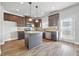 Well-lit kitchen featuring stainless steel appliances, granite countertops, an island, and hardwood floors at 2098 Bridgewater Pass, Hampton, GA 30228