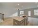 Modern kitchen with a center island and stainless steel sink overlooking the large open living space at 313 Heavenly Hollow Pl, Mcdonough, GA 30253