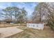 View of backyard including a large storage building and concrete parking pad at 4624 College St, Forest Park, GA 30297