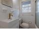 Clean bathroom featuring a unique vessel sink and a white tiled tub with a glass door at 4624 College St, Forest Park, GA 30297