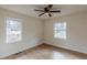 This bedroom has wood-look floors, ceiling fan, and double windows offering natural light at 4624 College St, Forest Park, GA 30297