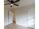 Well-lit bedroom with ceiling fan, wood-look floors, and convenient closet and hall access at 4624 College St, Forest Park, GA 30297