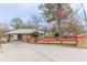 Home's front exterior featuring a cozy facade with driveway and a red wooden fence at 4624 College St, Forest Park, GA 30297