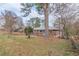 Home's front yard featuring a neatly maintained lawn, mature trees and a fenced perimeter at 4624 College St, Forest Park, GA 30297