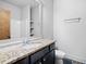 Bathroom vanity featuring granite countertop, dark cabinets, and an ample mirror at 507 Ridge View Xing, Woodstock, GA 30188