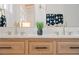 Close up of a wood grain vanity with double sinks and gold faucets, complemented by elegant decor at 2111 Drew Valley Ne Rd, Brookhaven, GA 30319