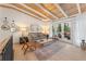 Comfortable living room featuring wood ceiling beams, decor, and access to an outdoor deck at 2111 Drew Valley Ne Rd, Brookhaven, GA 30319