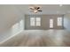 Bright living room features wood floors, a ceiling fan, and natural light from the windows and glass door at 321 Heavenly Hollow Pl, Mcdonough, GA 30253