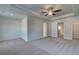 Spacious carpeted main bedroom with a trey ceiling, ceiling fan, and multiple entry points at 321 Heavenly Hollow Pl, Mcdonough, GA 30253