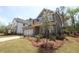 New home with a combination of brick and gray siding, complemented by lush landscaping and a two car garage at 4445 Beechnut Cir, Cumming, GA 30028