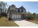 Two-story home featuring brick and gray siding, with a spacious driveway and attached two-car garage at 4445 Beechnut Cir, Cumming, GA 30028