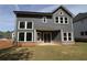 The rear of the house features gray siding, a brick foundation and a walk out to the lawn at 4445 Beechnut Cir, Cumming, GA 30028