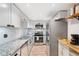 Modern kitchen featuring granite countertops, stainless steel appliances, white subway tile backsplash, and wood-look flooring at 6851 Roswell Rd # M12, Sandy Springs, GA 30328