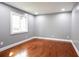 A bright bedroom featuring hardwood floors, neutral gray walls, and a large window at 10664 Sandpiper Road Rd, Jonesboro, GA 30238
