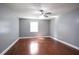Spacious bedroom with hardwood floors, gray walls, a ceiling fan, and a window with natural light at 10664 Sandpiper Road Rd, Jonesboro, GA 30238