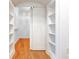 Walk-in closet featuring hardwood floors, sliding door, and built-in shelving at 3445 Stratford Ne Rd # 2403, Atlanta, GA 30326