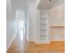 Bright hallway leading to kitchen featuring hardwood floors and built-in shelving at 3445 Stratford Ne Rd # 2403, Atlanta, GA 30326