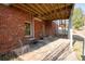 Rear brick wall of home showing a small patio with furniture and stairs leading to backyard at 1030 Silver Thorne Dr, Loganville, GA 30052