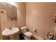 Bright half bath featuring a pedestal sink, modern faucet, and sleek white toilet for guests' convenience at 1030 Silver Thorne Dr, Loganville, GA 30052