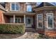 Inviting stone and brick entryway with columns, decorative door, and manicured hedges on a sunny day at 1030 Silver Thorne Dr, Loganville, GA 30052