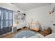 Bright Bedroom featuring stylish shelving, a modern crib, a comfy chair, and a fun alphabet rug at 127 Harlow Cir, Roswell, GA 30076