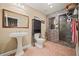 Well-lit bathroom featuring a vessel sink, tiled shower with glass door, and modern fixtures at 3591 Lochwolde Ln, Snellville, GA 30039