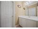 Bathroom featuring white vanity with drawers and doors, a decorative mirror, and modern lighting at 3591 Lochwolde Ln, Snellville, GA 30039