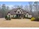 Elegant two-story brick home boasts a manicured lawn and mature trees, offering timeless curb appeal at 3591 Lochwolde Ln, Snellville, GA 30039