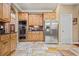 A kitchen with light brown cabinets, stainless steel appliances, and beautiful stone tile floors at 3591 Lochwolde Ln, Snellville, GA 30039