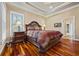 Cozy main bedroom with tray ceiling, hardwood floors, and side door at 3591 Lochwolde Ln, Snellville, GA 30039