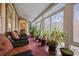 Bright sunroom with brick accent wall, large windows, comfortable seating, and an abundance of houseplants at 3591 Lochwolde Ln, Snellville, GA 30039