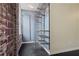 Modern open closet with metal shelving and rod, alongside exposed brick wall and natural light at 800 Peachtree Ne St # 8508, Atlanta, GA 30308