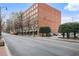 Exterior shot of brick building, showing the street view with trees and parked cars at 800 Peachtree Ne St # 8508, Atlanta, GA 30308