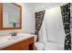 Bathroom featuring decorative shower curtain, wood vanity, and neutral tile flooring at 1434 Hampton Glen Ct, Decatur, GA 30033