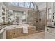 Main bathroom featuring a large tub, separate glass shower, tile surround, and marble countertop at 1845 Habersham Trce, Cumming, GA 30041