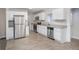 Modern kitchen with stainless steel appliances, granite countertops, white cabinets, and wood-look floors at 3005 Hidden Dr, Lawrenceville, GA 30044
