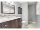 Bathroom with dark vanity, marble countertop, framed mirror, and tiled shower at 1495 Harbour Oaks Rd, Tucker, GA 30084