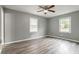 Bright bedroom features gray walls, wood-look floors, ceiling fan and two windows at 1495 Harbour Oaks Rd, Tucker, GA 30084