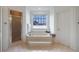 Bathroom featuring a soaking tub with window view and a separate glass-enclosed shower at 400 Laurel Chase Ct, Atlanta, GA 30327