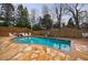 Backyard pool surrounded by stone and wood deck, and a wood privacy fence at 400 Laurel Chase Ct, Atlanta, GA 30327