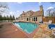 Backyard pool surrounded by wood and stone decking with home reflecting in the water at 400 Laurel Chase Ct, Atlanta, GA 30327