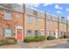 Brick townhomes with a grey roof, various colored doors, and lush green landscaping at 265 Winding River Dr # F, Atlanta, GA 30350
