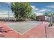 Outdoor community tennis court with mature tree and lights at 265 Winding River Dr # F, Atlanta, GA 30350