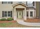 Inviting front entrance featuring stone accents, a covered porch, and a decorative front door at 15 Streamside Dr, Covington, GA 30016