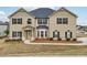 Two-story home with tan siding, stone accents, and a well-maintained front yard at 15 Streamside Dr, Covington, GA 30016