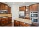 Elegant kitchen featuring stainless steel appliances, granite countertops, and wooden cabinets at 15 Streamside Dr, Covington, GA 30016