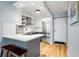 This shows a well-lit kitchen with stainless steel appliances, a farmhouse sink, seating, and an entryway to the unit at 2870 Pharr Nw Ct # 2008, Atlanta, GA 30305