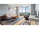 Light-filled living room featuring contemporary furniture, hardwood floors, a work space, and expansive floor-to-ceiling windows at 2870 Pharr Nw Ct # 2008, Atlanta, GA 30305